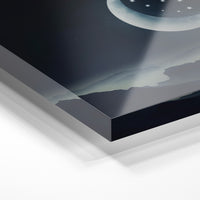 Gros plan de la matière : le tirage sous verre acrylique, tranche transparente visible.
