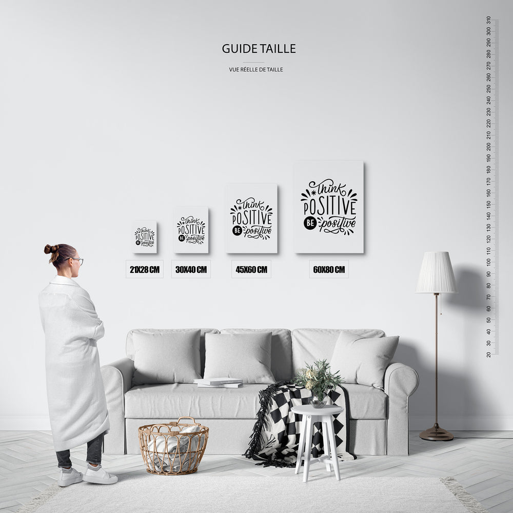 Guide des tailles : le tirage présenté dans ses 4 formats de vente, à l'échelle réelle sur un mur de salon, avec une règle en centimètres.
