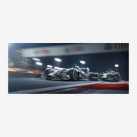 Deux voitures de course monoplace circulant à haute vitesse sur un circuit de nuit, éclairées par les projecteurs du stade.