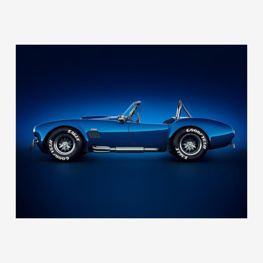 Roadster cabriolet bleu électrique de profil, toit rétractable ouvert, sur fond bleu dégradé.