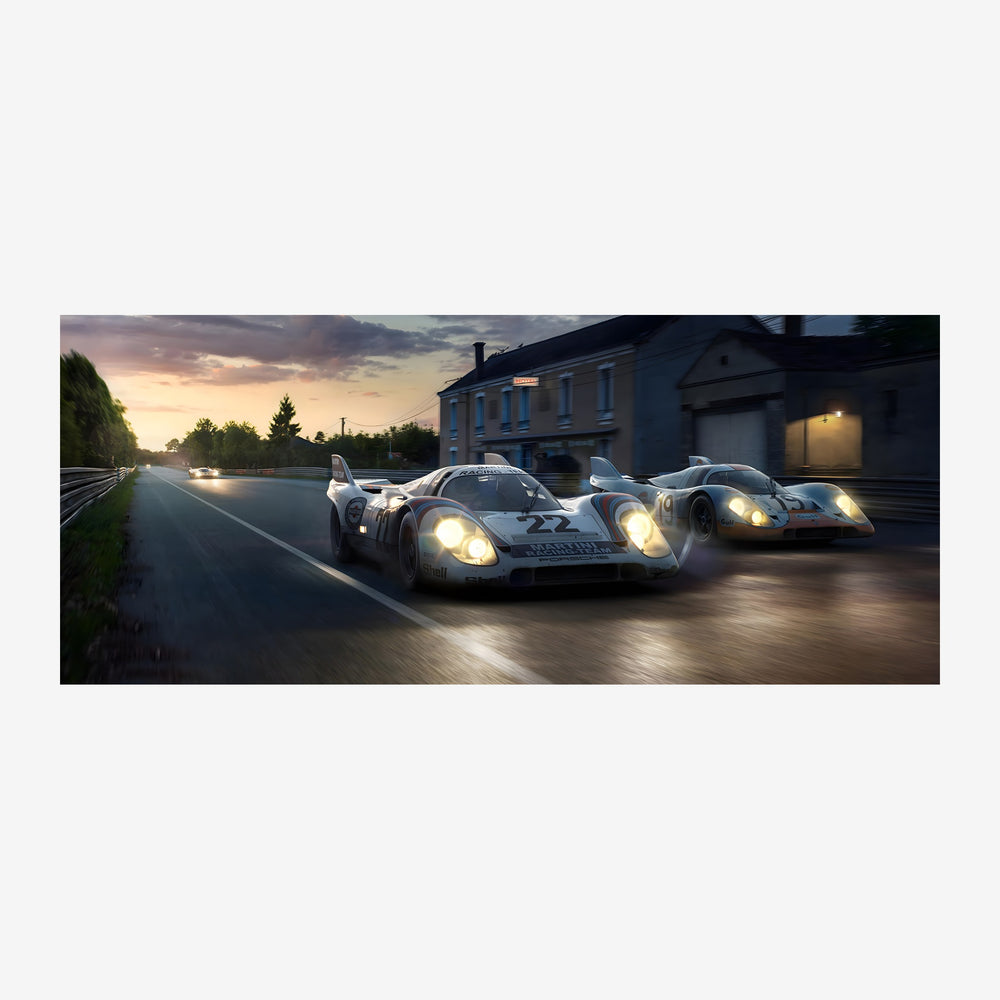 Trois voitures de sport blanches et grises sur un circuit routier au crépuscule, avec une maison bleue en arrière-plan et un.