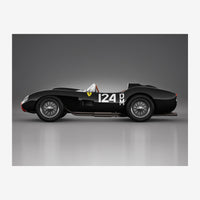 Voiture de course vintage noire avec le numéro 124, photographiée de profil sur fond gris clair.
