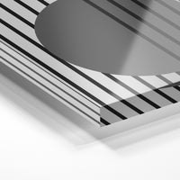 Gros plan de la matière : le tirage sous verre acrylique, tranche transparente visible.
