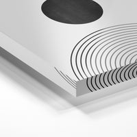 Gros plan de la matière : le tirage sous verre acrylique, tranche transparente visible.
