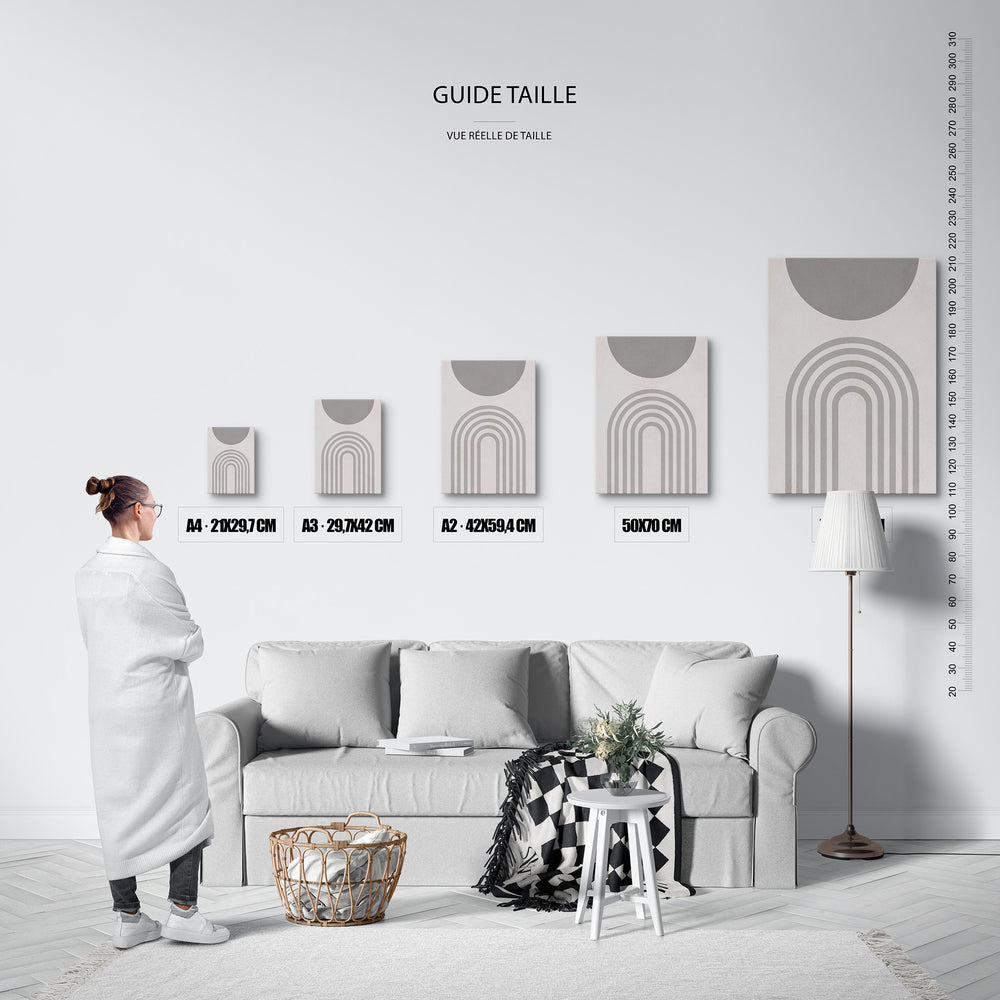 Guide des tailles : le tirage présenté dans ses 5 formats de vente, à l'échelle réelle sur un mur de salon, avec une règle en centimètres.