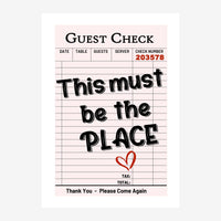 Imitation de ticket de restaurant sur fond rose pâle, avec le texte « This must be the place » en grands caractères noirs et.