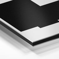 Gros plan de la matière : le tirage contrecollé sur aluminium Dibond mat, tranche visible.