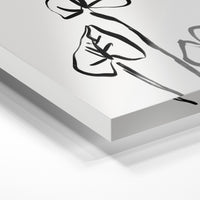 Gros plan de la matière : le tirage sous verre acrylique, tranche transparente visible.