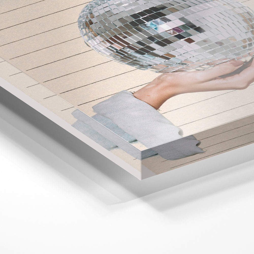 Gros plan de la matière : le tirage sous verre acrylique, tranche transparente visible.