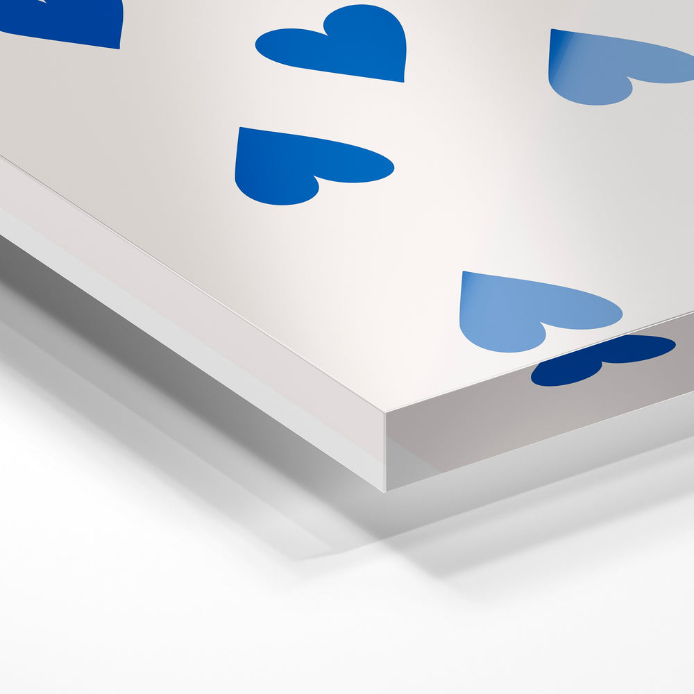 Gros plan de la matière : le tirage sous verre acrylique, tranche transparente visible.