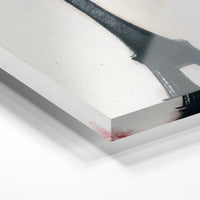 Gros plan de la matière : le tirage sous verre acrylique, tranche transparente visible.
