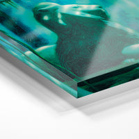 Gros plan de la matière : le tirage sous verre acrylique, tranche transparente visible.