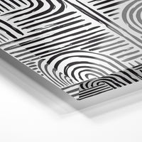 Gros plan de la matière : le tirage sous verre acrylique, tranche transparente visible.