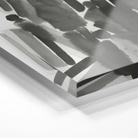 Gros plan de la matière : le tirage sous verre acrylique, tranche transparente visible.