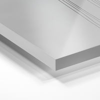 Gros plan de la matière : le tirage sous verre acrylique, tranche transparente visible.