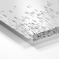 Gros plan de la matière : le tirage sous verre acrylique, tranche transparente visible.