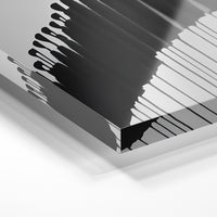 Gros plan de la matière : le tirage sous verre acrylique, tranche transparente visible.