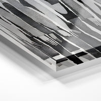 Gros plan de la matière : le tirage sous verre acrylique, tranche transparente visible.