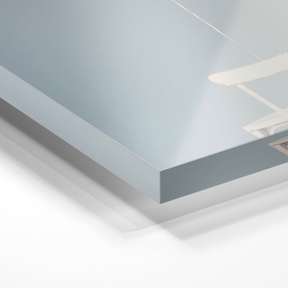 Gros plan de la matière : le tirage sous verre acrylique, tranche transparente visible.