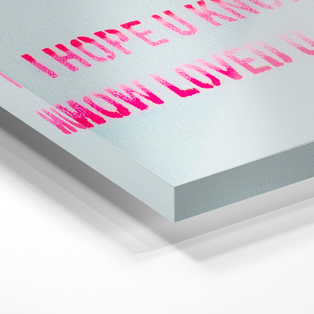Gros plan de la matière : le tirage sous verre acrylique, tranche transparente visible.