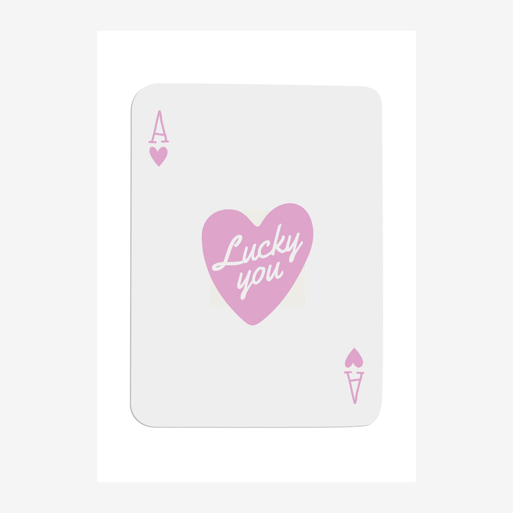 Une carte à jouer rose et blanche avec un as de cœur en haut à gauche, un grand cœur rose contenant le texte « Lucky you ».