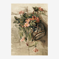 Bouquet de fleurs rose et terracotta dans un vase suspendu par des cordes, feuillage vert, sur fond beige avec architecture.