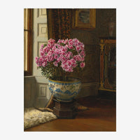 Un bouquet de pivoines roses arrangé dans un vase en porcelaine bleu et blanc, posé sur un socle dans une pièce aux murs.