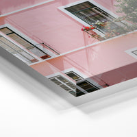 Gros plan de la matière : le tirage sous verre acrylique, tranche transparente visible.