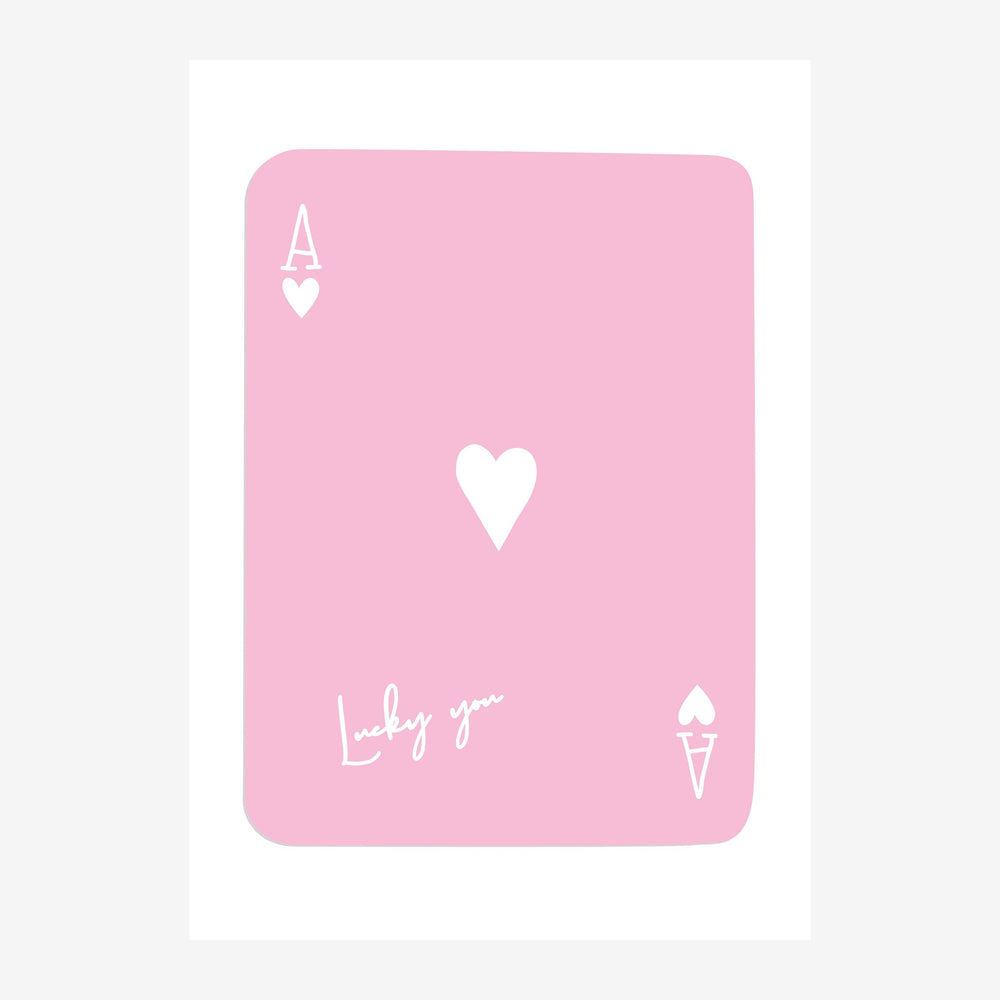 Affiche représentant une carte à jouer rose poudré avec un grand cœur blanc au centre, bordée de symboles de trèfle et de.