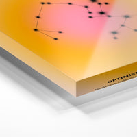 Gros plan de la matière : le tirage sous verre acrylique, tranche transparente visible.