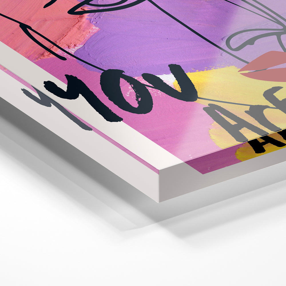 Gros plan de la matière : le tirage sous verre acrylique, tranche transparente visible.