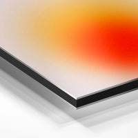 Gros plan de la matière : le tirage contrecollé sur aluminium Dibond mat, tranche visible.