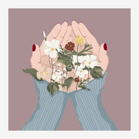 Deux mains aux ongles rouges, vêtues d'un pull bleu côtelé, cueillent un bouquet de petites fleurs blanches et brunes sur.