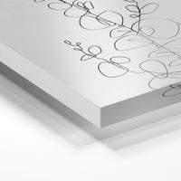 Gros plan de la matière : le tirage sous verre acrylique, tranche transparente visible.