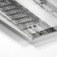 Gros plan de la matière : le tirage sous verre acrylique, tranche transparente visible.