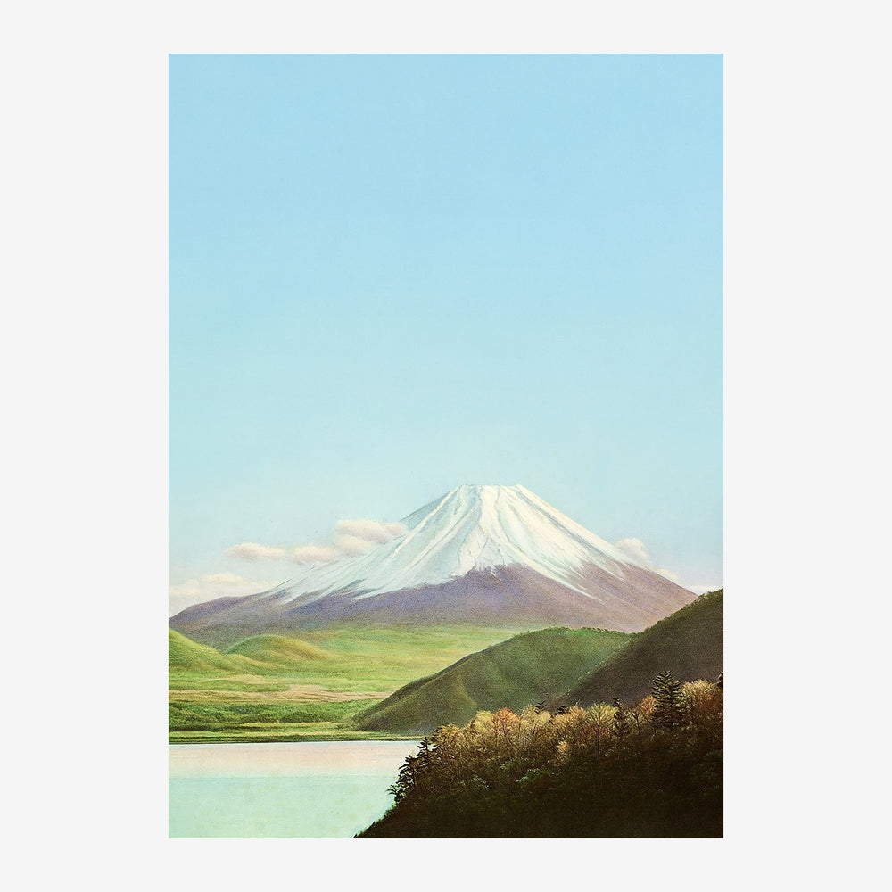 Paysage de montagne avec sommet enneigé blanc dominant une vallée verte, lac turquoise en avant-plan, ciel bleu clair.