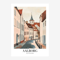 Vue perspective d'une rue pavée bordée de maisons historiques pastel et terracotta, avec une église au clocher vert en.